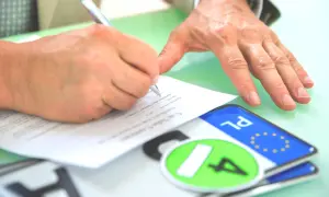 Podpisanie umowy kupna-sprzedaży pojazdu, tuż po rejestracja. Na stole leżą tablice rejestracyjne.
