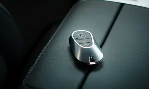 Elegancki kluczyk Mercedes z systemem keyless spoczywa na skórzanej konsoli.