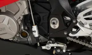 Mechanizm quickshifter co to? Widok na silnik motocykla BMW z elementami układu zmiany biegów, w tym siłownikiem quickshifter.
