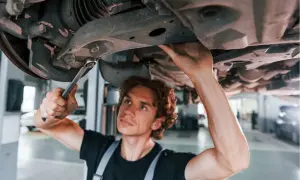 Mechanik naprawia zawieszenie, by uniknąć problemów z jazdą z uszkodzoną tuleją wahacza.