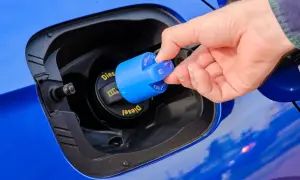 Dłoń zdejmuje niebieską zakrętkę z napisem AdBlue. To płyn do redukcji emisji spalin w dieslach.