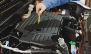 Mechanik sprawdza poziom oleju silnikowego. W tym miejscu zazwyczaj znajduje się bagnet, a nie wlew oleju do skrzyni biegów.