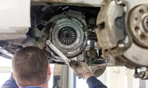 Mechanik dokręca śruby koła zamachowego. Czas pracy, ile trwa wymiana sprzęgła, zależy od modelu auta i doświadczenia.