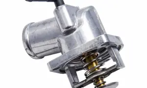 Metalowy termostat w samochodzie, kluczowy element układu chłodzenia, z widoczną sprężyną i zaworem.