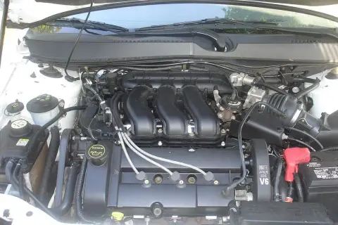 Silnik V6 Duratec w Ford Mondeo MK4. Widać przewody, akumulator i elementy układu dolotowego.