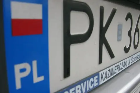 Zbliżenie na polską tablicę rejestracyjną z oznaczeniem PK. Widoczna flaga Polski i napis PL.