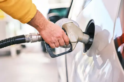 Dłoń tankuje samochód. Czy silnik wysokoprężny to diesel czy benzyna? Odpowiedź zależy od modelu auta.