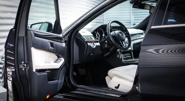 Wnętrze luksusowego Mercedesa z białymi skórzanymi fotelami. Zastanawiasz się, keyless entry co to jest? To wygoda bez kluczyka.