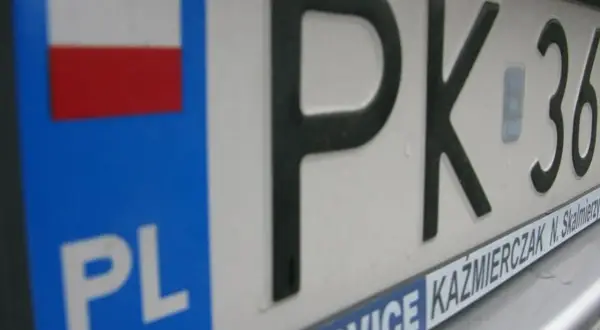 Zbliżenie na polską tablicę rejestracyjną z oznaczeniem PK. Widoczna flaga Polski i napis PL.