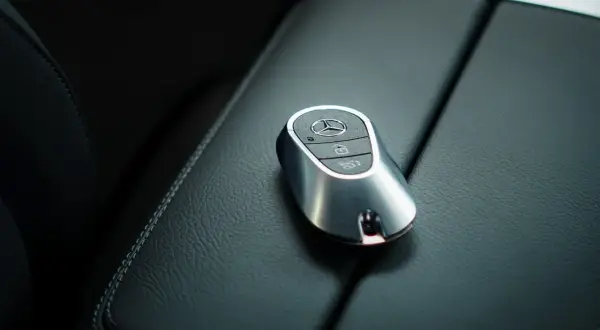 Elegancki kluczyk Mercedes z systemem keyless spoczywa na skórzanej konsoli.