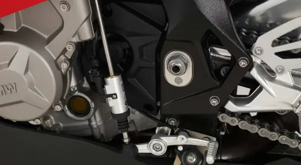 Mechanizm quickshifter co to? Widok na silnik motocykla BMW z elementami układu zmiany biegów, w tym siłownikiem quickshifter.