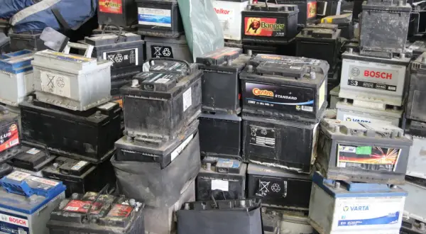 Stosy zużytych akumulatorów samochodowych, gotowych do recyklingu. Widać napisy marek jak Bosch, Varta, Centra. To miejsce, gdzie można oddać stary akumulator, a czasem nawet otrzymać zwrot kaucji za akumulator.