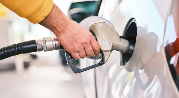 Dłoń tankuje samochód. Czy silnik wysokoprężny to diesel czy benzyna? Odpowiedź zależy od modelu auta.