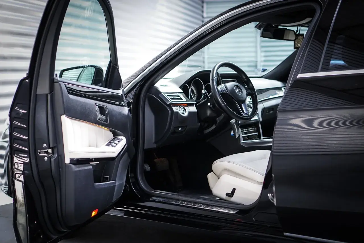 Wnętrze luksusowego Mercedesa z białymi skórzanymi fotelami. Zastanawiasz się, keyless entry co to jest? To wygoda bez kluczyka.