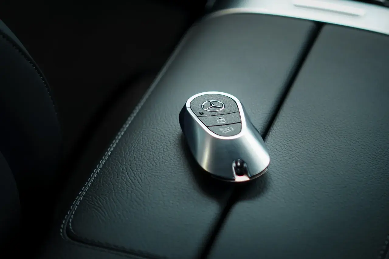 Elegancki kluczyk Mercedes z systemem keyless spoczywa na skórzanej konsoli.