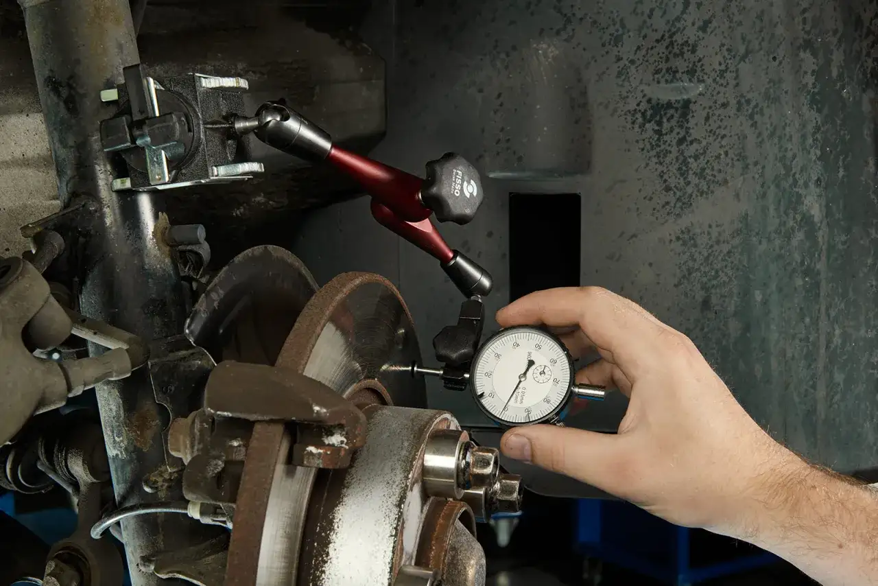 Mechanik mierzy bicie tarczy hamulcowej za pomocą zegara, aby wykluczyć efekt shimmy.