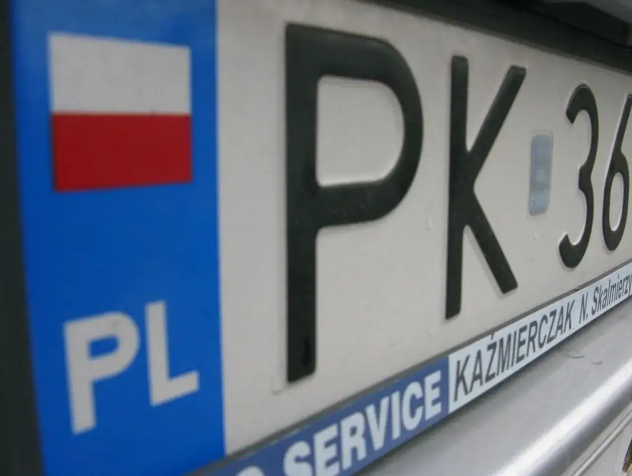 Zbliżenie na polską tablicę rejestracyjną PK 36. Widoczna flaga Polski i oznaczenie PL.
