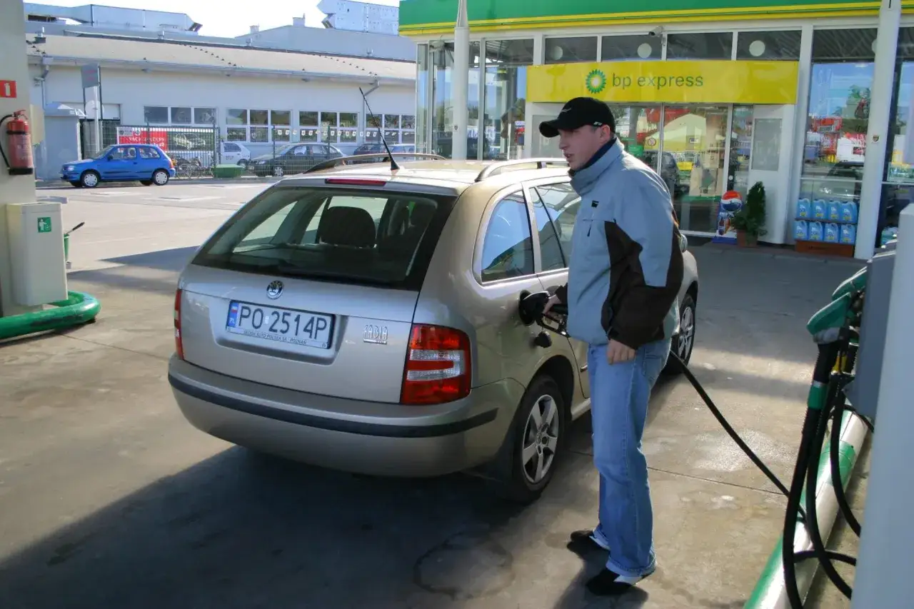 Mężczyzna tankuje samoch&oacute;d na stacji BP. Obliczenie spalania jest proste, gdy wiesz, ile paliwa wlałeś i ile kilometr&oacute;w przejechałeś.