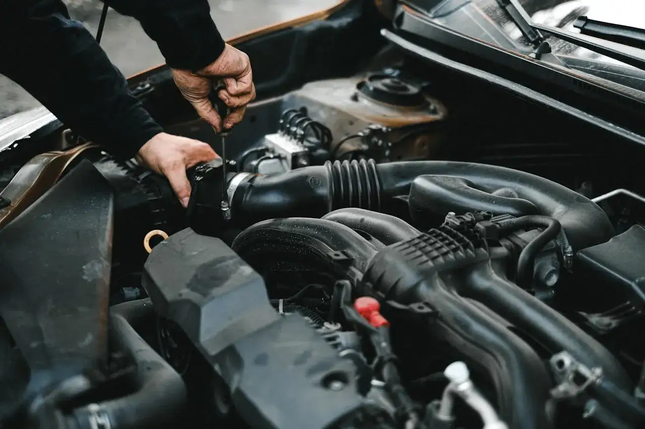 Mechanik dokręca śrubę przy silniku. Może to być związane z uszkodzonym przekaźnikiem pompy paliwa objawy, kt&oacute;re utrudniają pracę auta.
