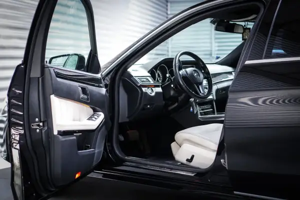 Wnętrze luksusowego Mercedesa z białymi skórzanymi fotelami. Zastanawiasz się, keyless entry co to jest? To wygoda bez kluczyka.