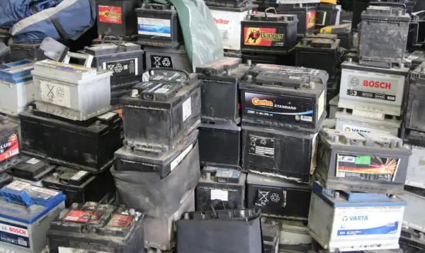 Stosy zużytych akumulatorów samochodowych, gotowych do recyklingu. Widać napisy marek jak Bosch, Varta, Centra. To miejsce, gdzie można oddać stary akumulator, a czasem nawet otrzymać zwrot kaucji za akumulator.