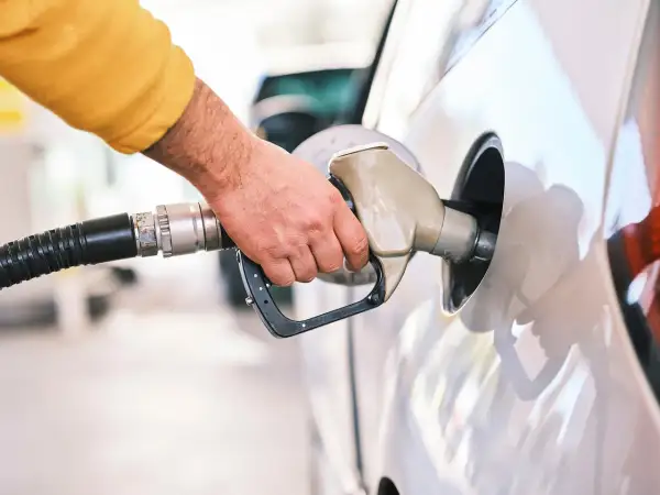 Dłoń tankuje samochód. Czy silnik wysokoprężny to diesel czy benzyna? Odpowiedź zależy od modelu auta.